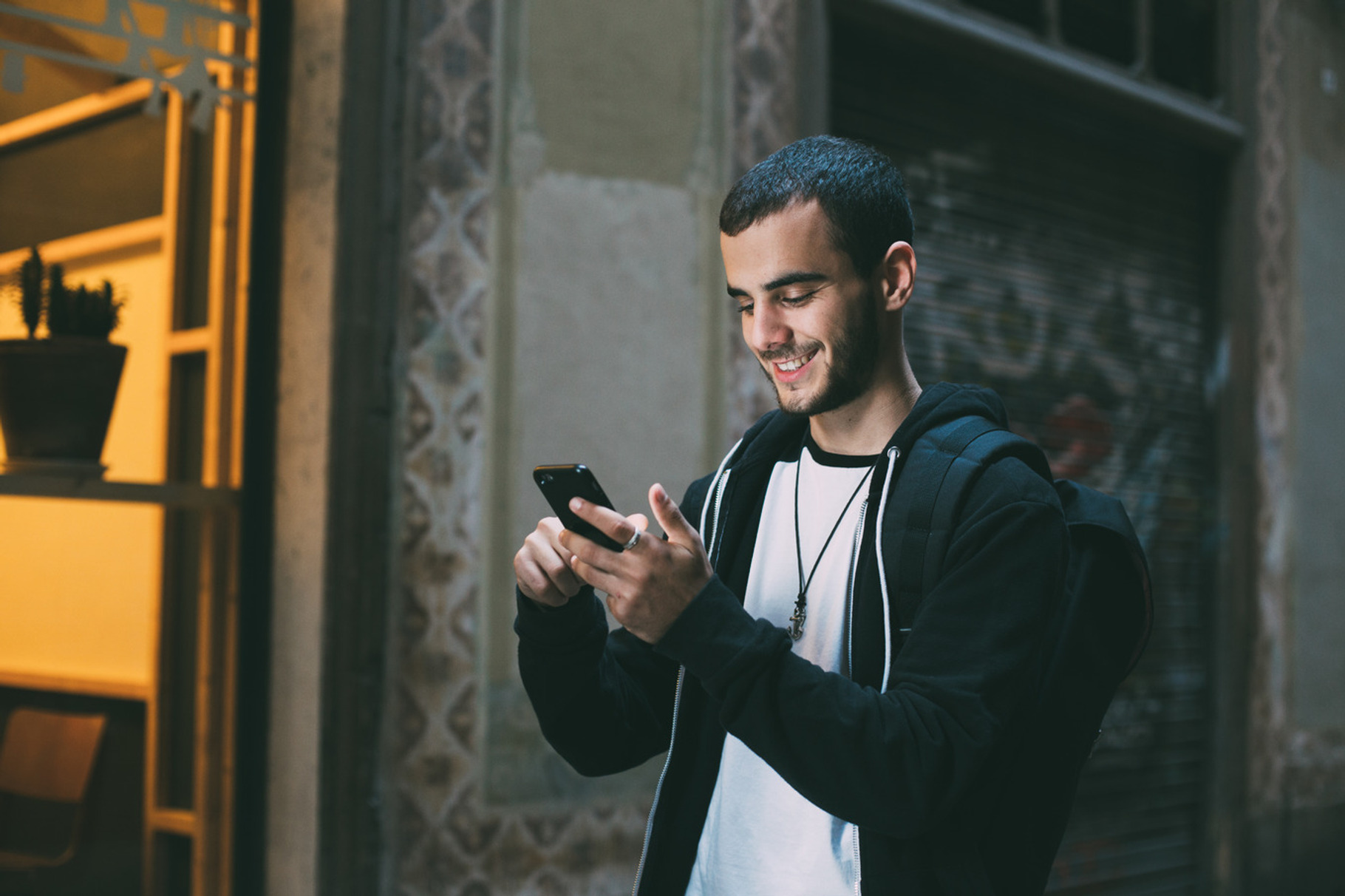 Handsome millennial uses phone, a Technology Photo by DeRepente