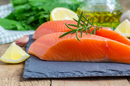 Fresh raw salmon fillet with rosemary and lemon, a Food & Drink Photo by iuliia_n