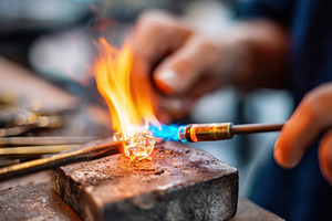 Artisan heating glass with torch, an Industrial Photo by AlyaAnd