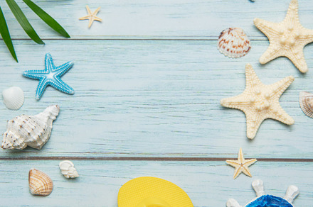 Summer essentials creating a frame on a light blue wooden backgr