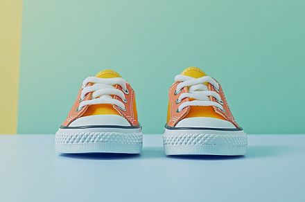 Children sneakers against color minimalistic background, a Photo by Dvoevnore photos