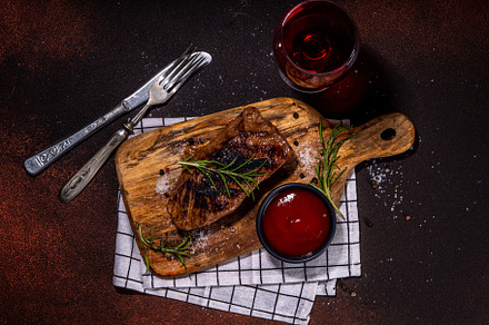 Grilled meat steak on dark table, a Food & Drink Photo by Rimma