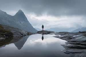 Man stands by tranquil mountain lake, a Photo by Beautiful things