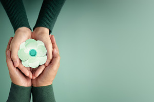 Two People  using Hands to Embracing a White Paper Poppy Flower, a Photo by salmon.black