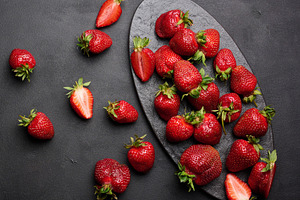 Fresh ripe strawberry on a dark background, whole berries and sl, a Food & Drink Photo by ndanko