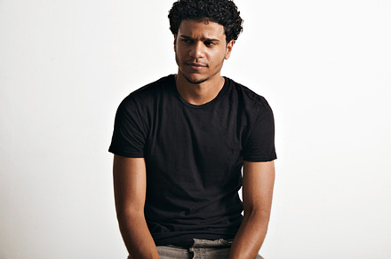 Portrait of a handsome man in black tshirt sitting containing t-shirt, a Person Photo by DeRepente