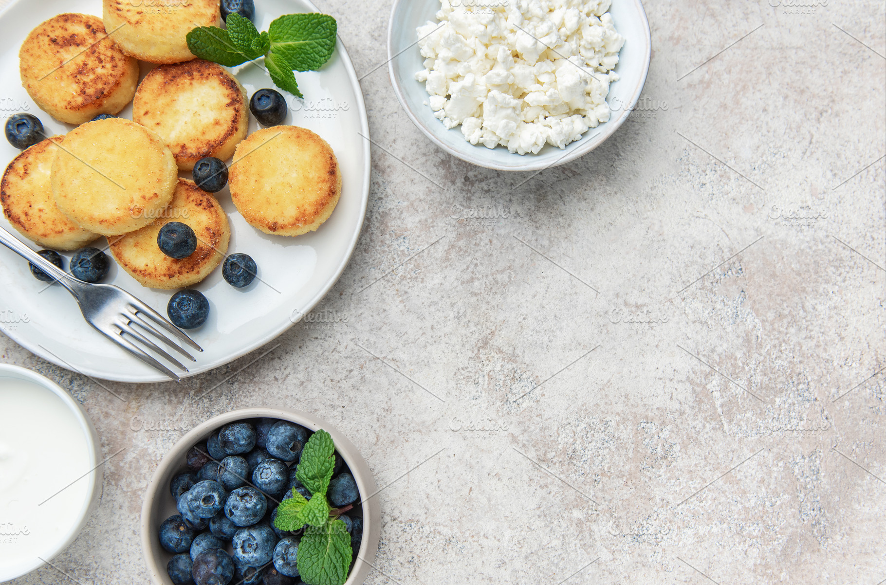 Syrniki cottage cheese pancakes served with fresh blueberries an, a Food & Drink Photo by Olena Rudo