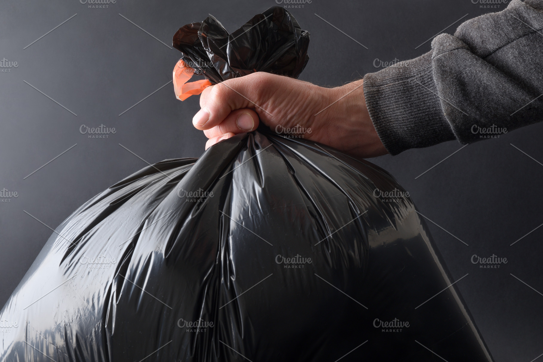 Detail of hand with garbage bag and isolated black background, a Nature Photo by Davizro's Market