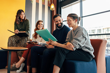 Team of happy businesspeople working in an office lobby, a Person Photo by Jacob Lund