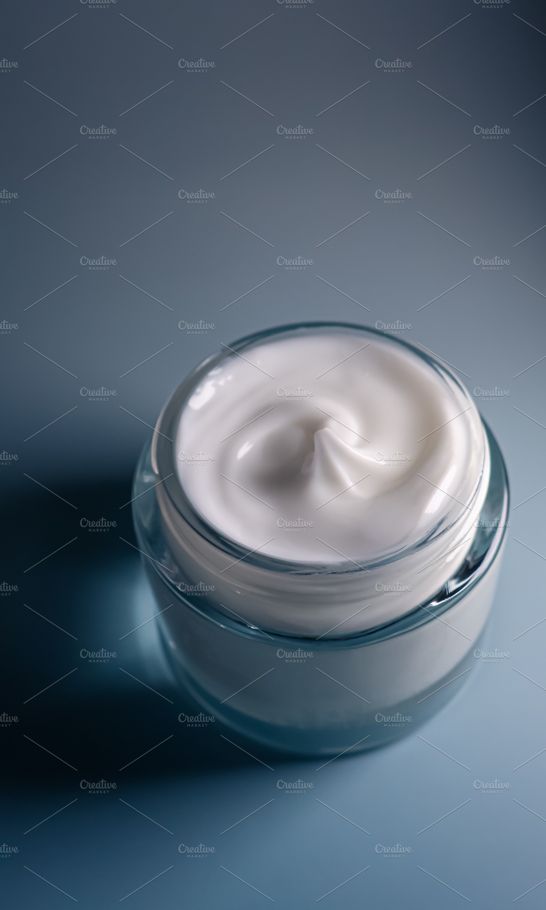 White face cream in a blue jar, symbolizing beauty, skincare, hydration, and co, a Photo by Studio ANNA