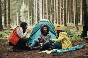 Women sitting at their campsite in the woods, a Person Photo by Stefan & Janni