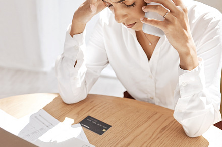 Black woman, phone call and credit card for debt, frustrated with bills and at desk with laptop. African American female, upset lady or cellphone for connection, communication or payment query stress, a Photo by Peopleimages.com