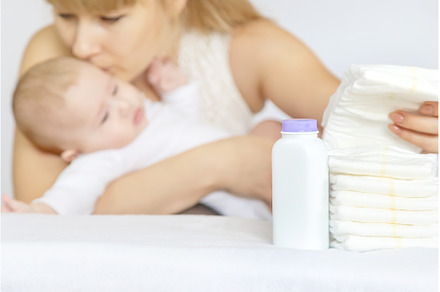 mother changes baby's diaper on a, a Person Photo by yanadjana