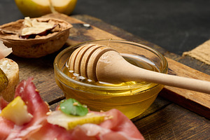 Close-up of a bowl of golden honey and a wooden honey spoon plac, a Food & Drink Photo by ndanko