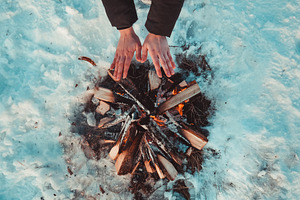 Women hands warm by the fire.