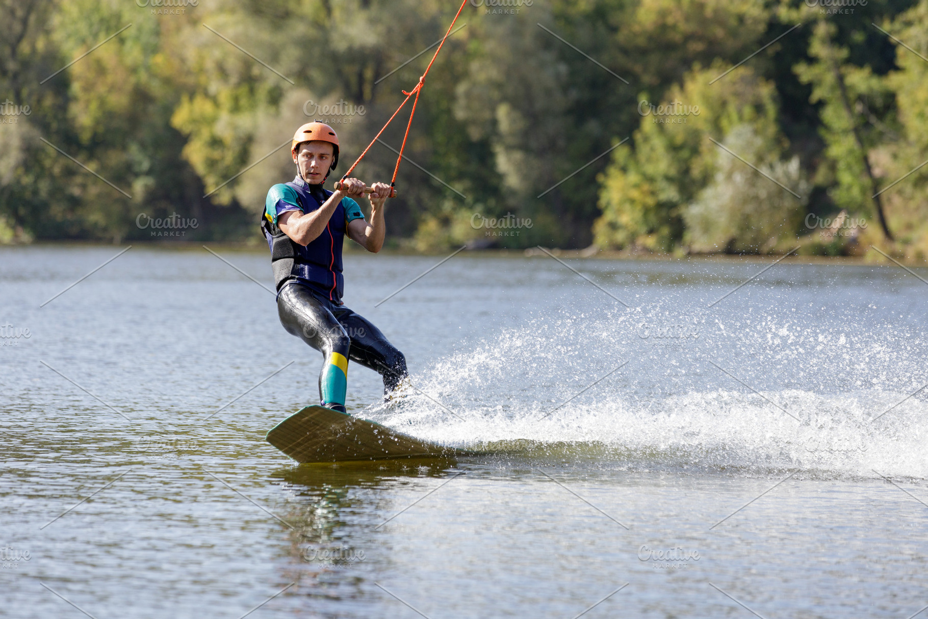 Young wakeboarder surfing along the river, a Sports & Recreation Photo by serkum