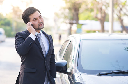 Businessman using a mobile at car stock photo containing 20s and 30s, a Person Photo by KHphotography