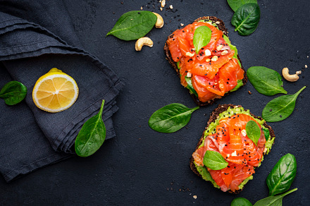 Avocado and salmon sandwich or toast on rye bread with spinach,, a Food & Drink Photo by 5PH