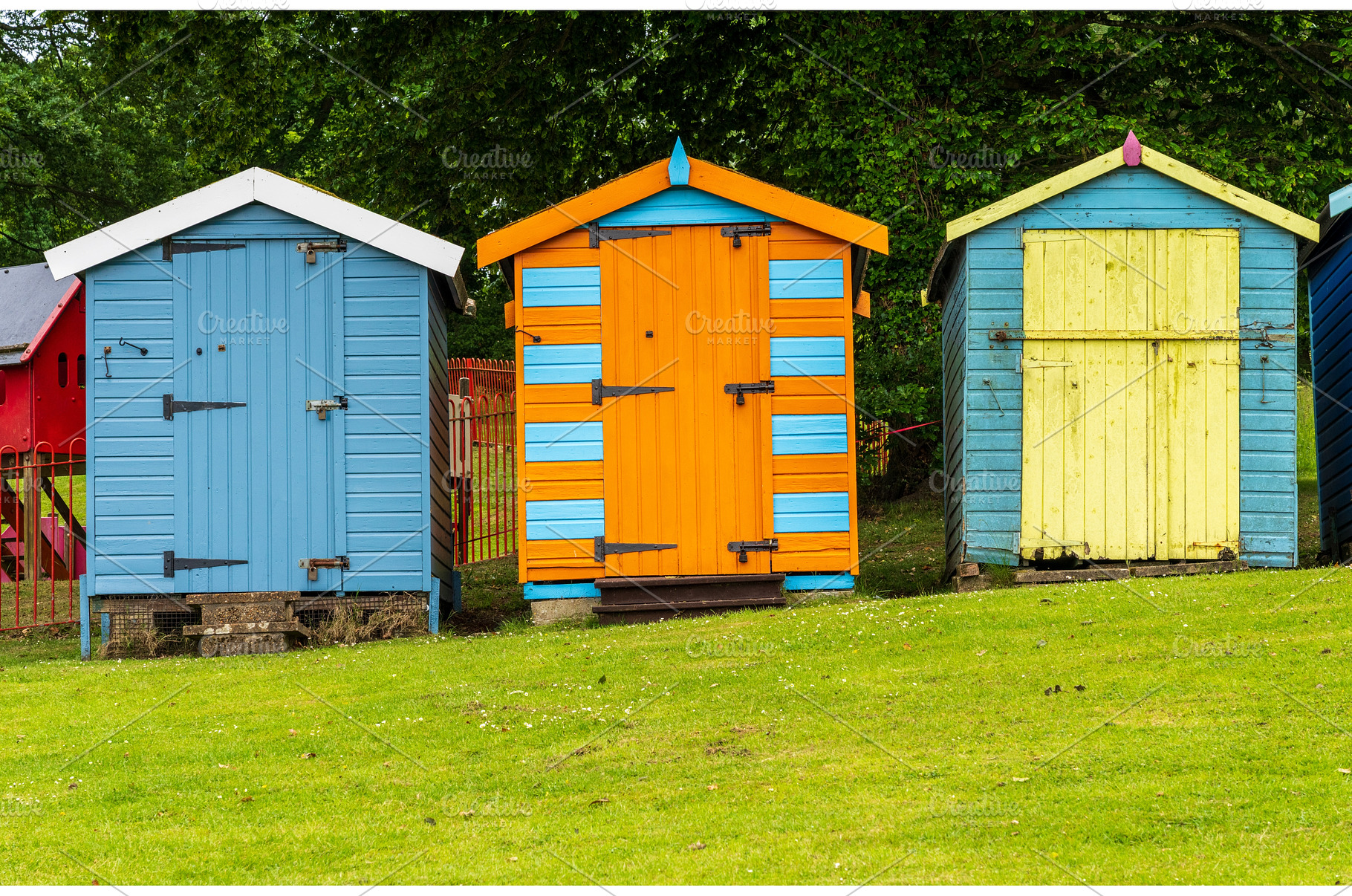 Three painted colourful beach huts, a Holiday Photo by Backyard Stock