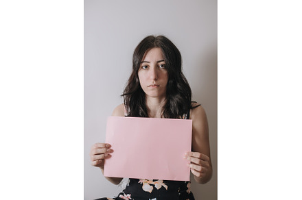 Sad young woman holding a blank, a Person Photo by zheckasmk