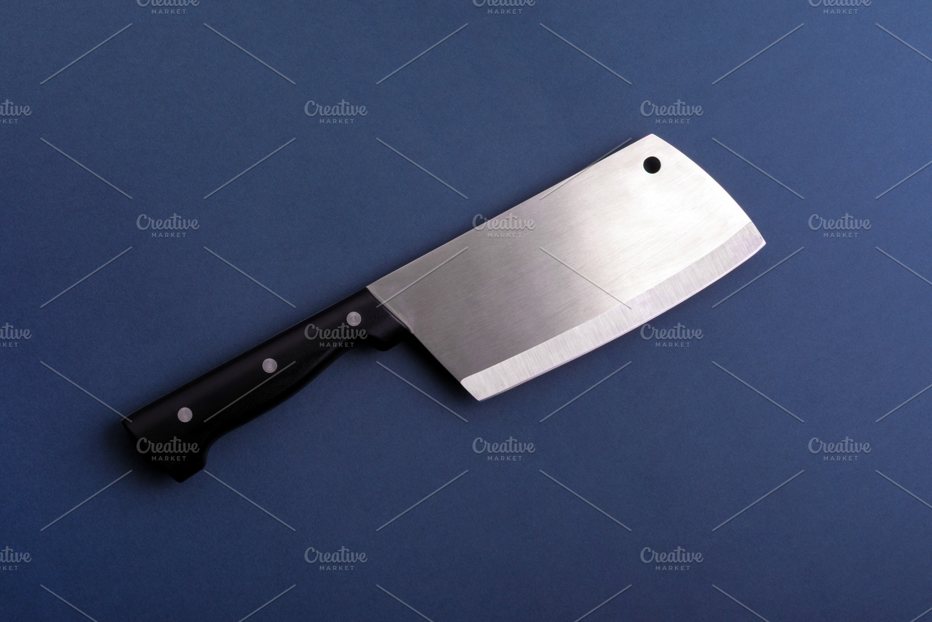 Large stainless steel cleaver with black handle on a blue backgr, a Food & Drink Photo by Ales Munt