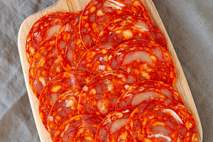 Cold Meat Chorizo Slices on a Wooden Board, top view., a Food & Drink Photo by LiudmylaChuhunova