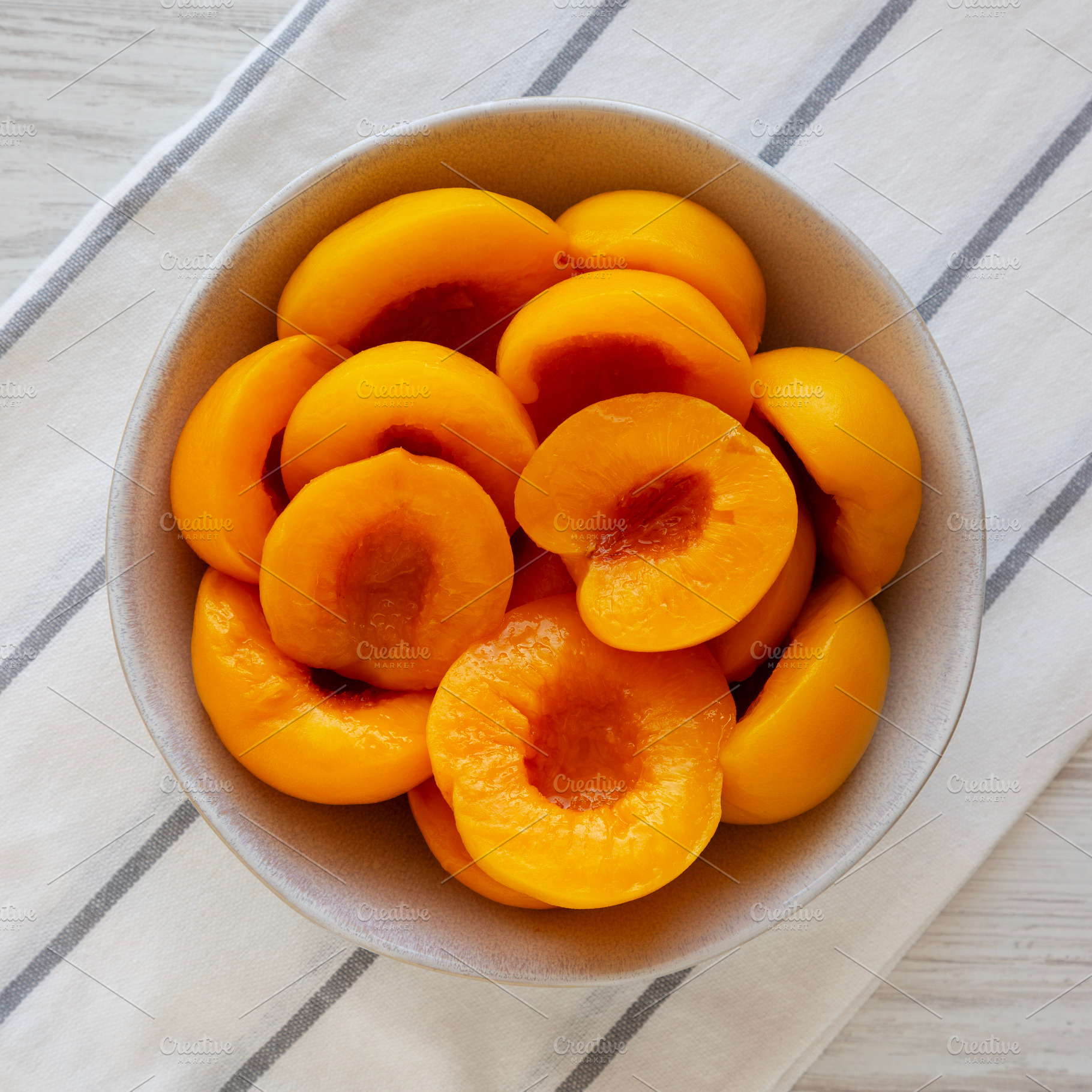Healthy Organic Canned Peach Halves in a Bowl, top view., a Food & Drink Photo by LiudmylaChuhunova