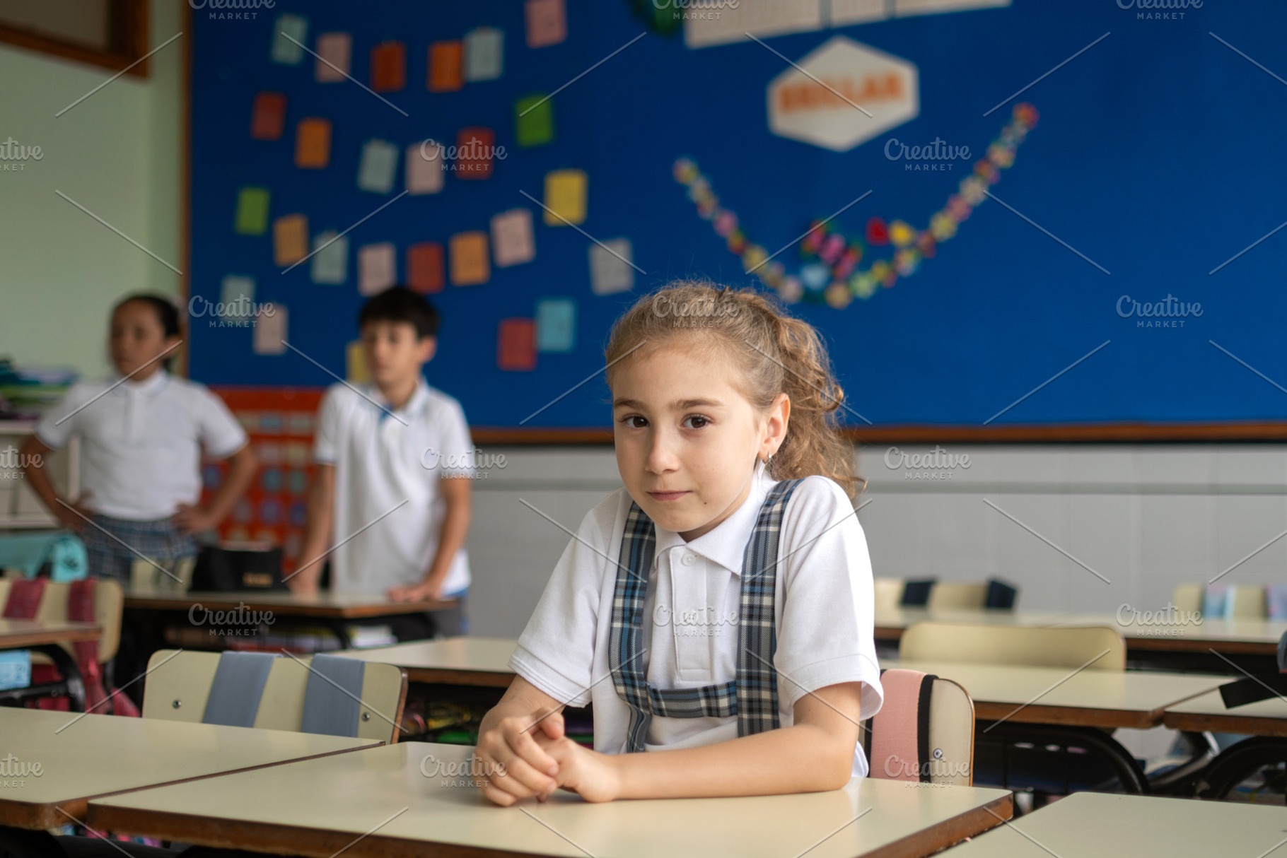 Elementary school girl sitting alone at her desk in a classroom, a School & Education Photo by etorres69