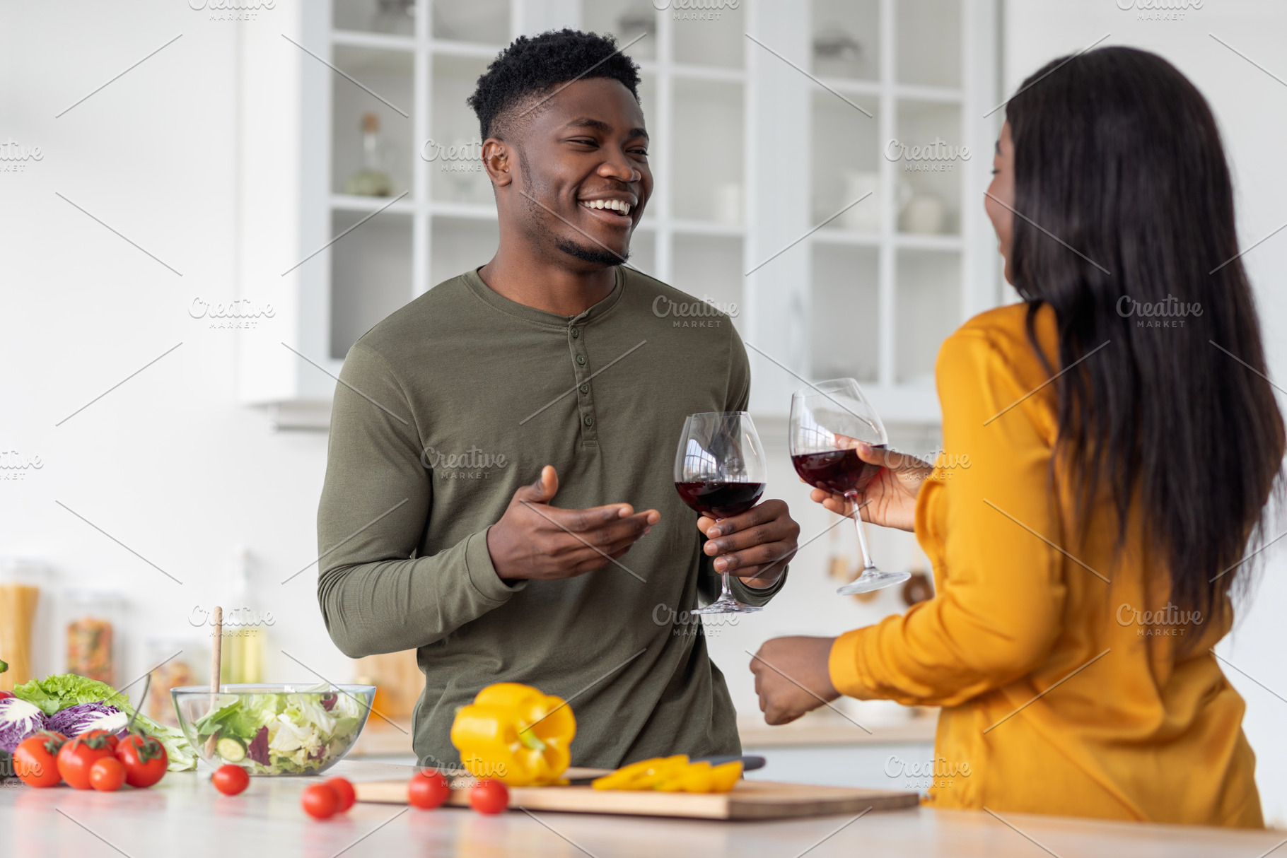Aperitif Drink. Cheerful Black Man And Woman Drinking Red Wine In Kitchen, a Photo by Prostock-Studio
