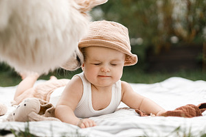 Cute dog licking beautiful happy baby on blanket with toys on ba, a Person Photo by Sonjachni