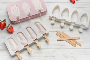 Preparing homemade strawberry ice cream bars in silicone molds, a Food & Drink Photo by Olena Rudo