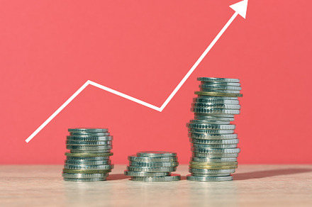 A stack of metallic coins and a graph on a red background. Incom, a Business Photo by ndanko