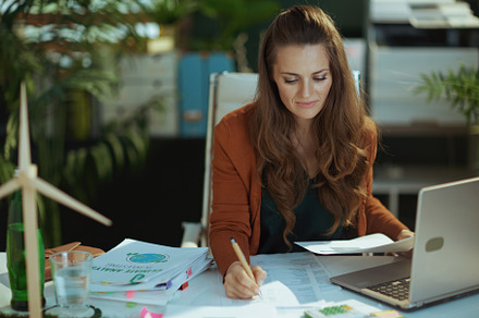 business owner woman in green office working with documents, a Business Photo by Alliance Images
