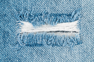 Blue denim fabric with ripped hole