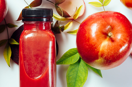 Red smoothie drink in bottle surrounded by red apples, tomatoes, a Food & Drink Photo by SZ IMAGE