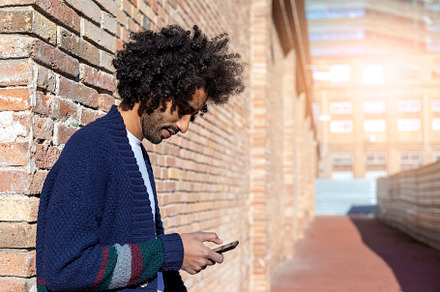 Young afro man using cellphone outdoor, a Person Photo by 2Design