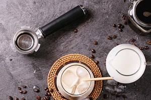 Glass of ice coffee with ice cubes served with cream, a Food & Drink Photo by RomanDebree