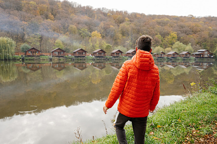 Boy against wooden houses with smoke on the lake. Reflections of, a Person Photo by AS photostudio