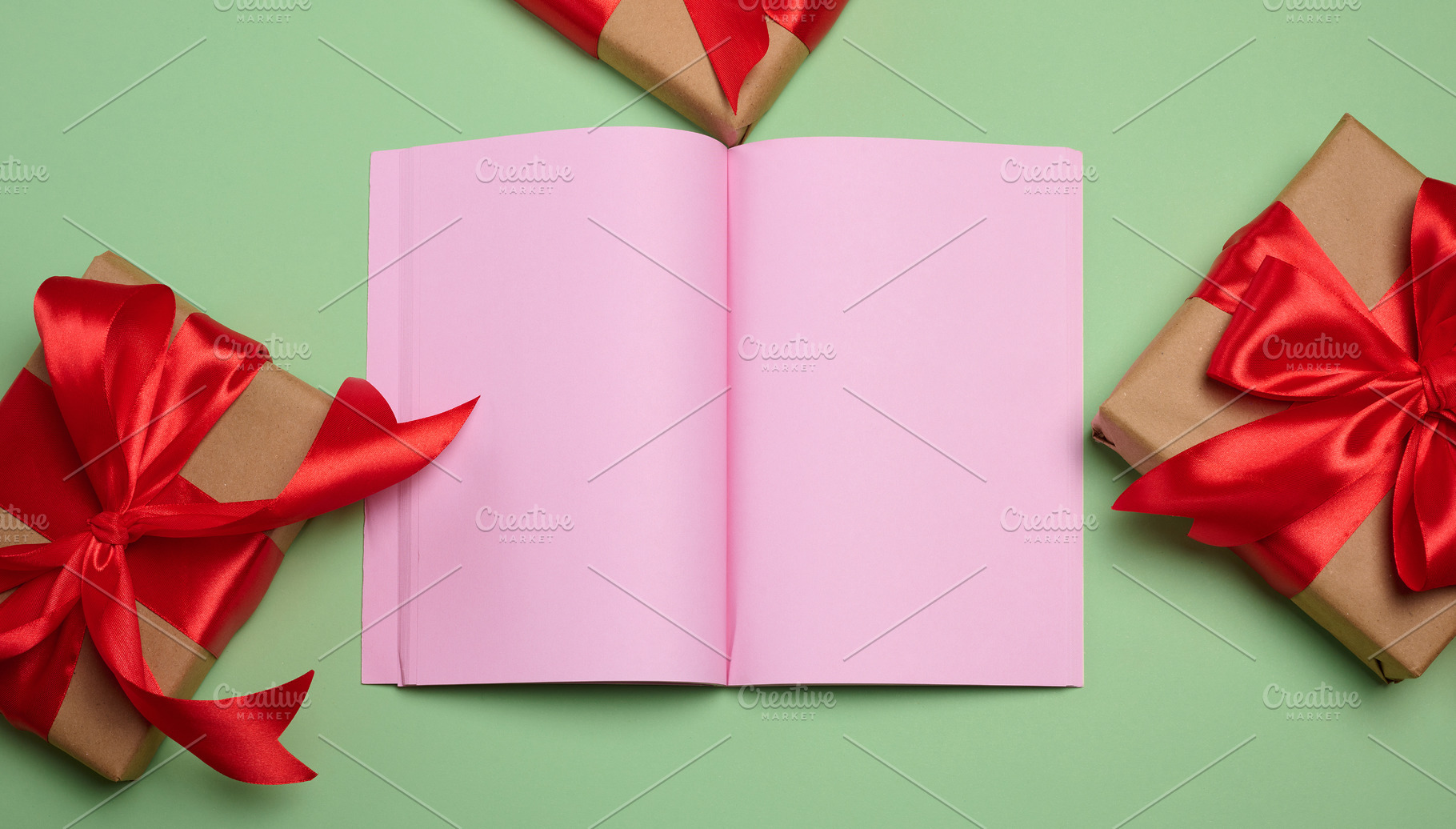 An open notebook with blank pink pages, centered, surrounded by, a Holiday Photo by ndanko