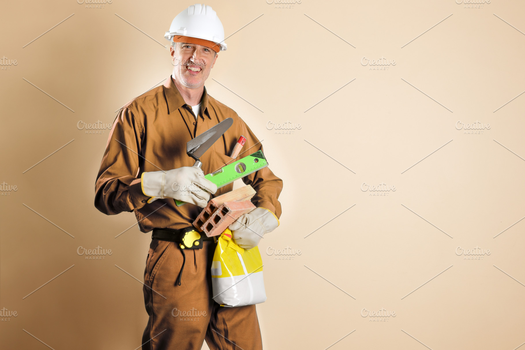Smiling bricklayer holding tools and building materials brown is, a Person Photo by Davizro's Market