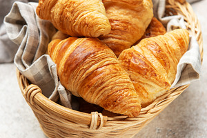 Golden brown croissants sit in a wicker basket, ready to be enjo, a Food & Drink Photo by Olena Rudo