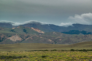 Mountains covered by big clouds at top, chubut province, argenti, a Photo by DanFLCreativo