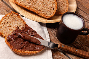 Spreading chocolate cream on whole wheat bread for breakfast with milk, a Food & Drink Photo by Antonio Gravante Market