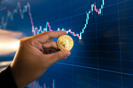 Bitcoin coins in hand in front of the computer, a Business Photo by Art Rachen