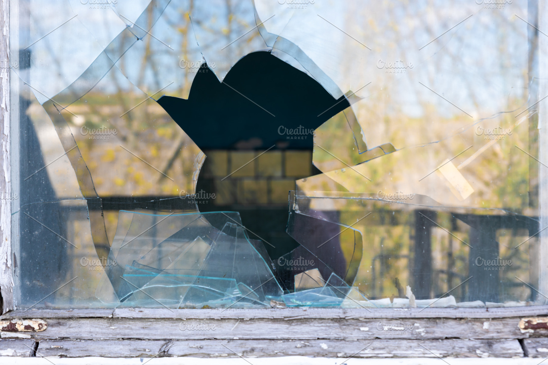 Shattered glass window with a large central hole, surrounded by, a Background Photo by Ales Munt