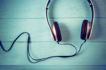 Headphones on blue wooden containing gadget, phones, and background, a Technology Photo by Nednapa