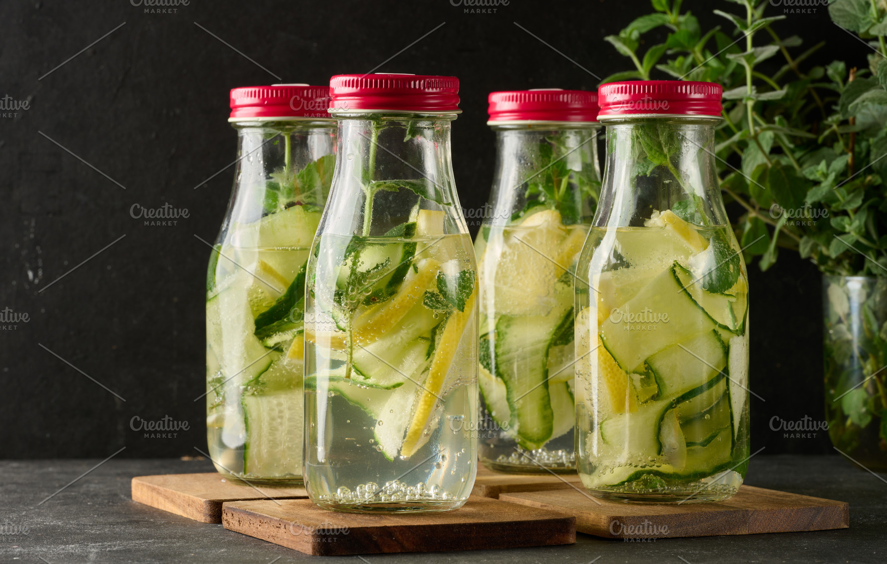 A row of glass bottles with red lids filled with refreshing deto, a Food & Drink Photo by ndanko