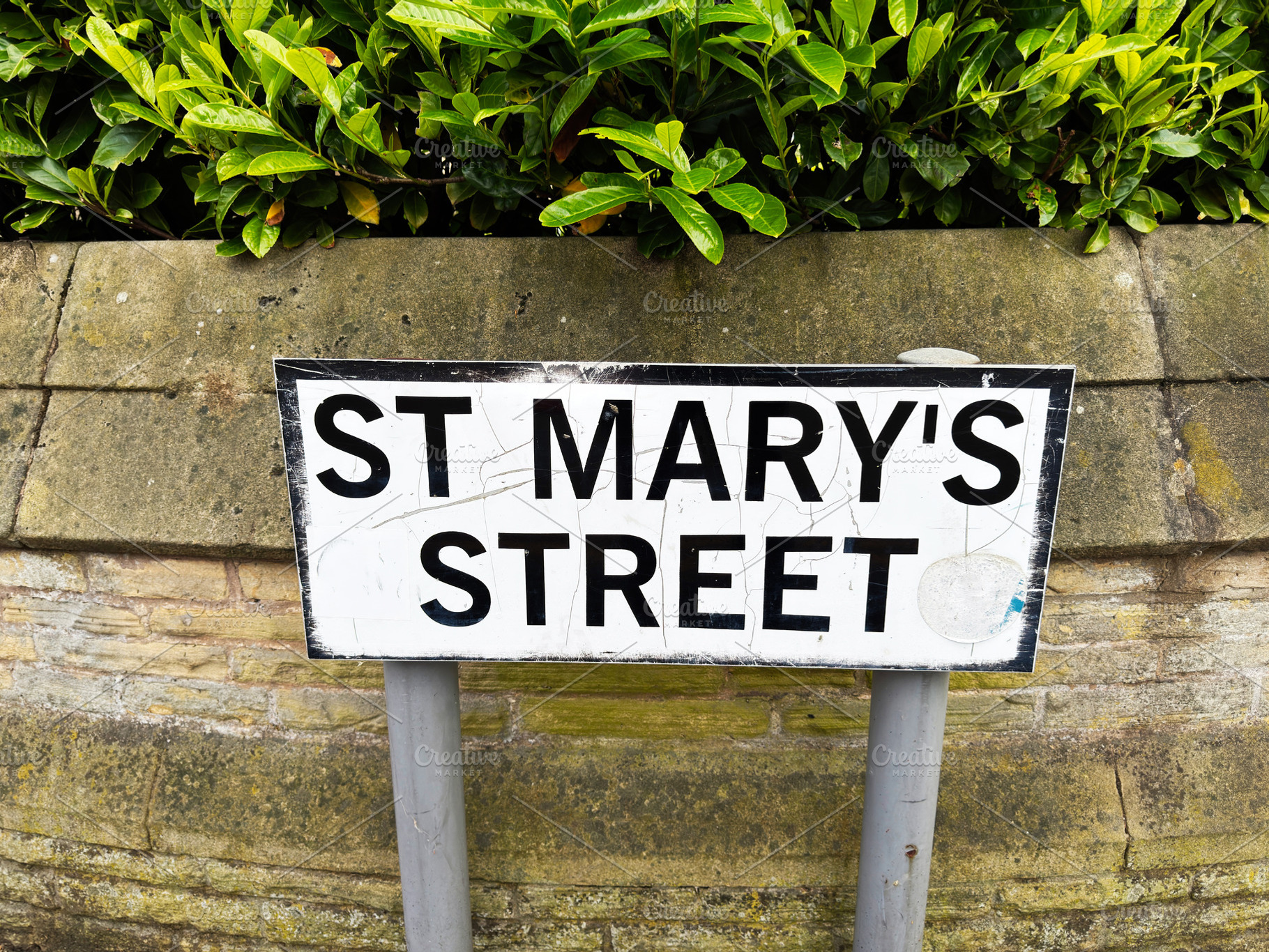 St Mary's Street sign on stone wall with green hedge in Manchest, a Photo by AS photostudio