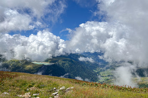 Cloudy alpine valley view from mountain meadow in Les Contamines, a Nature Photo by GoodGoods