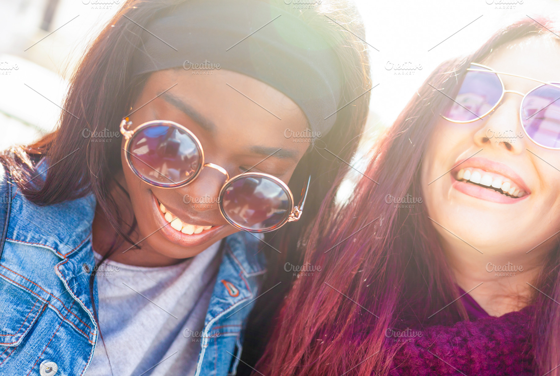 Two happy multi ethnic young women wearing sunglasses smiling together outdoors, a Person Photo by Antonio Gravante Market